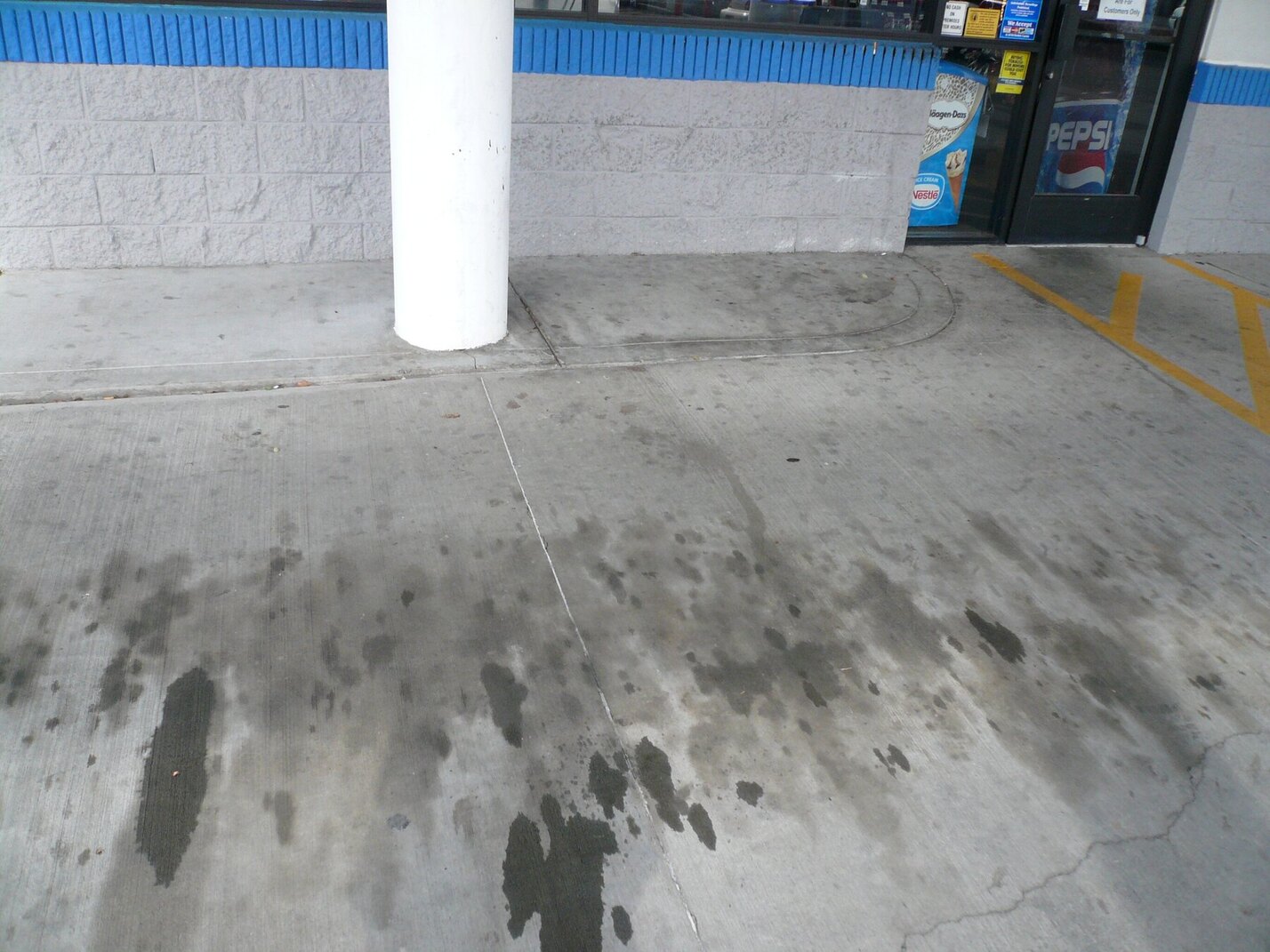 Concrete area with dark oil stains before EXIMO treatment